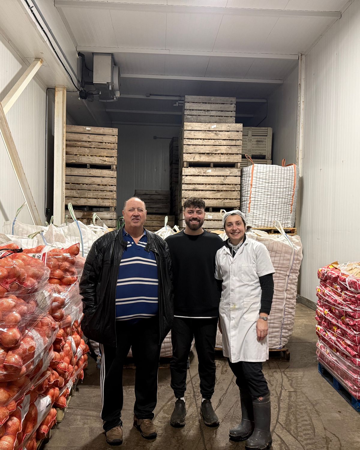 The Pericao family in the Potatoland cold storage, surrounded by pallets of fresh onions and potatoes